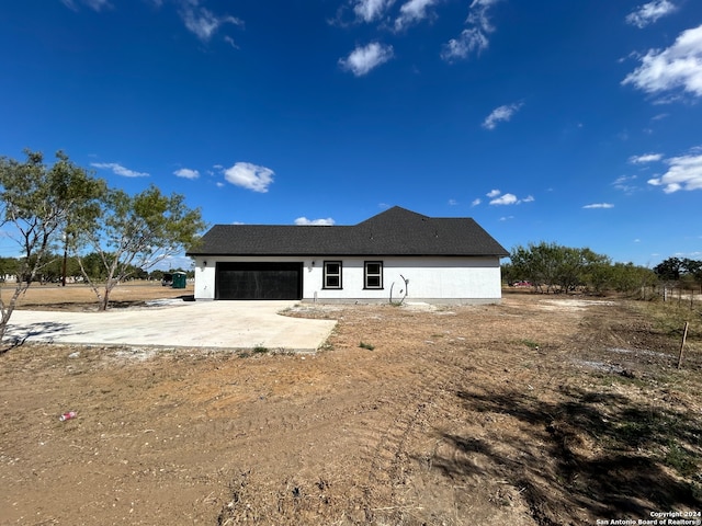 rear view of property with a garage