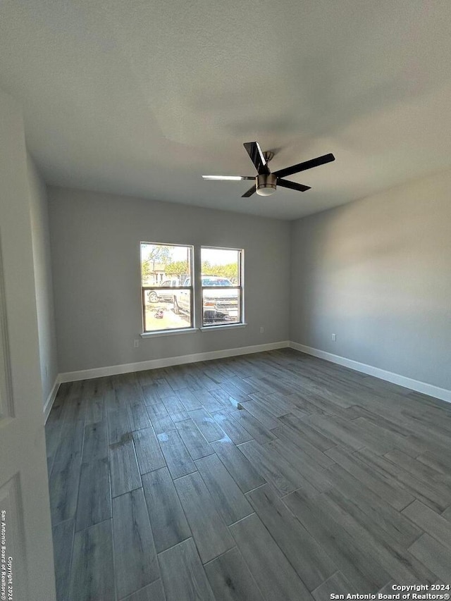 spare room with a textured ceiling, hardwood / wood-style flooring, and ceiling fan