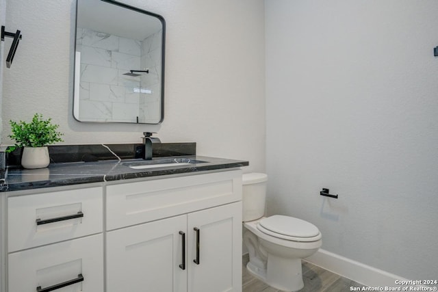 bathroom with a shower, vanity, wood-type flooring, and toilet