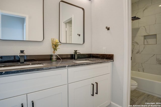 full bathroom with toilet, hardwood / wood-style floors, vanity, and tiled shower / bath combo