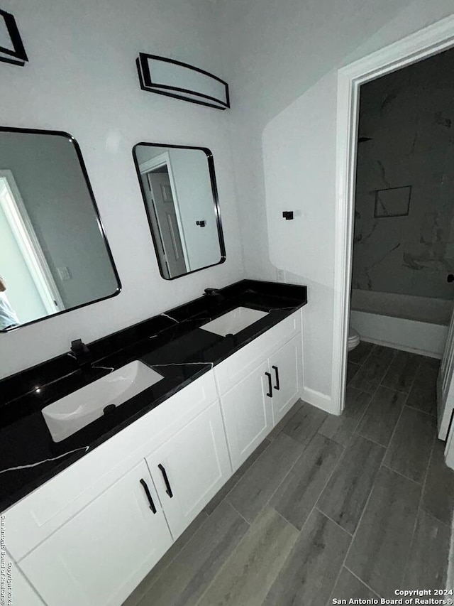 bathroom with vanity, toilet, and wood-type flooring