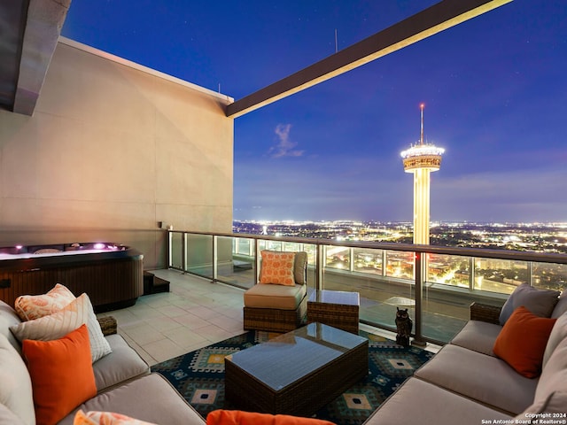 balcony at dusk with a hot tub and an outdoor living space