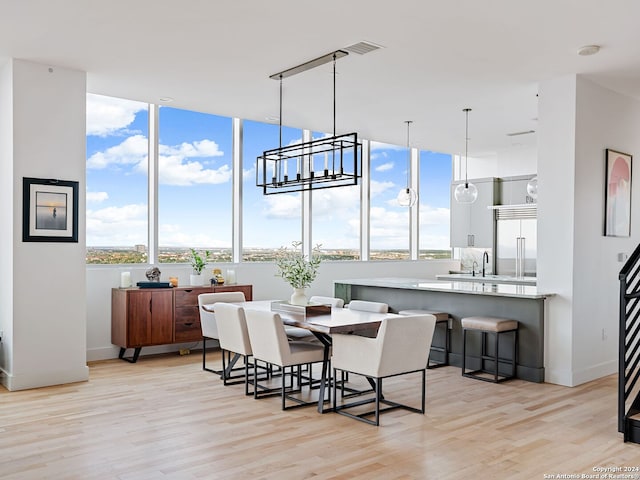 dining space featuring a healthy amount of sunlight, sink, and light wood-type flooring