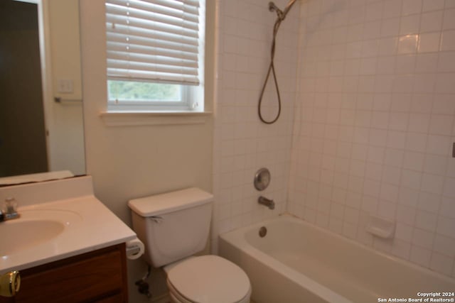 full bathroom featuring tiled shower / bath, vanity, and toilet