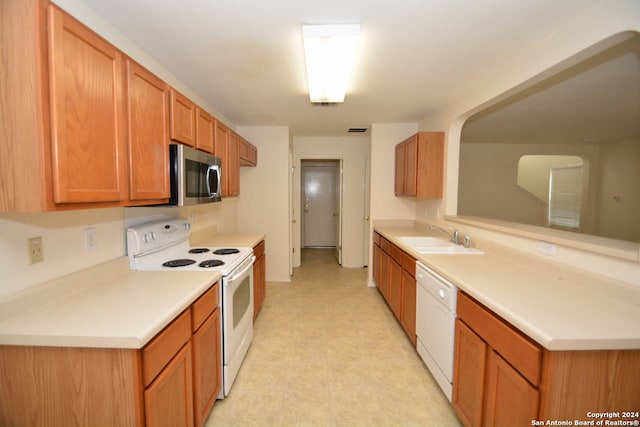 kitchen featuring white appliances and sink