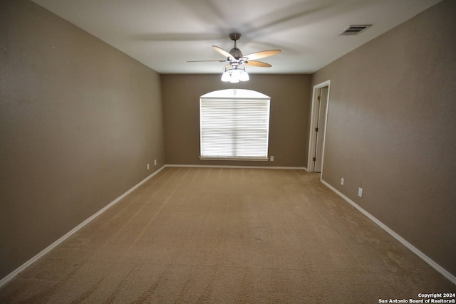 empty room featuring light colored carpet and ceiling fan