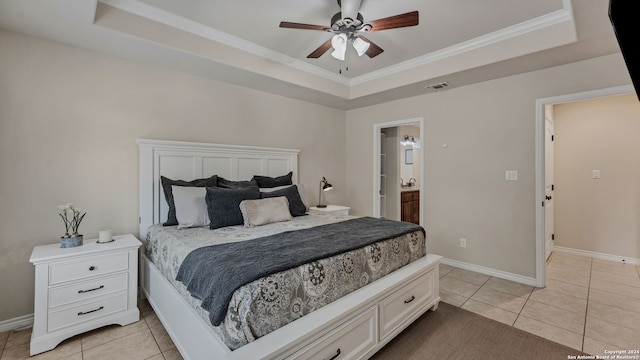 bedroom featuring ensuite bathroom, ornamental molding, a tray ceiling, and ceiling fan