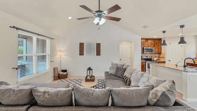 living room featuring light tile patterned flooring, sink, high vaulted ceiling, and ceiling fan