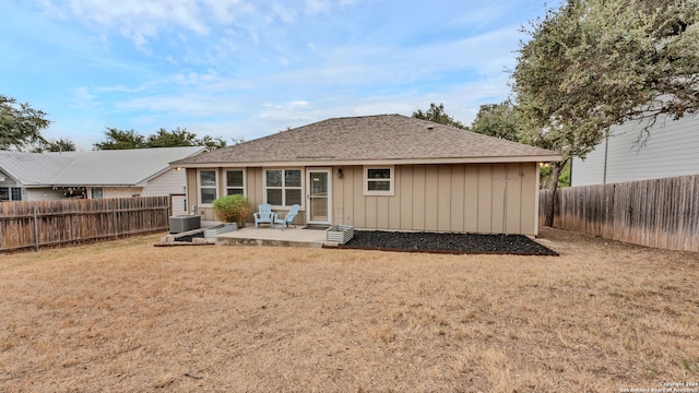 rear view of property with a patio, central AC, and a lawn