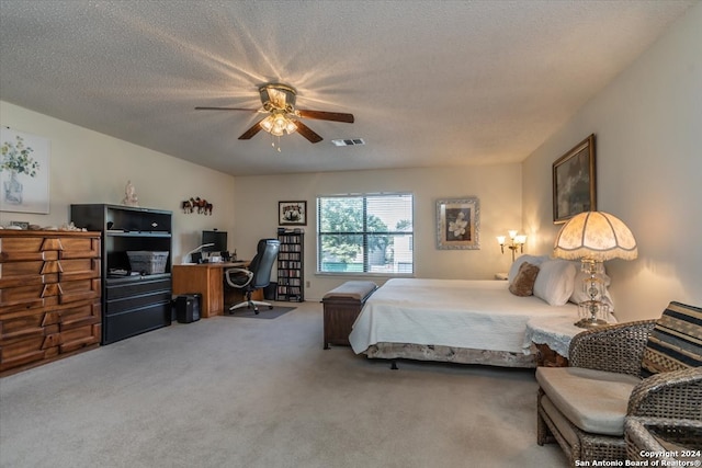 carpeted bedroom with ceiling fan and a textured ceiling