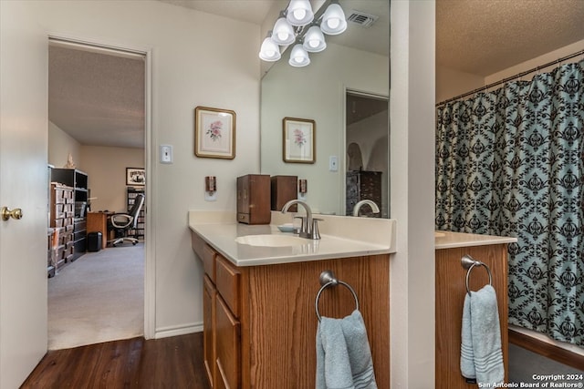 bathroom with vanity, a textured ceiling, and wood-type flooring