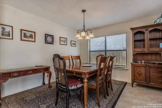 dining space featuring a textured ceiling, an inviting chandelier, and light colored carpet