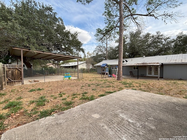 view of yard featuring fence, french doors, and a patio area