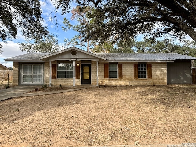 ranch-style house featuring fence and brick siding
