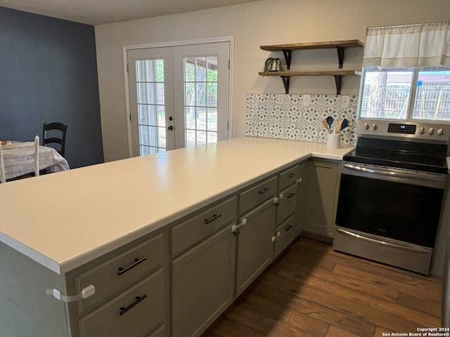 kitchen with french doors, dark hardwood / wood-style flooring, kitchen peninsula, gray cabinets, and stainless steel electric range oven