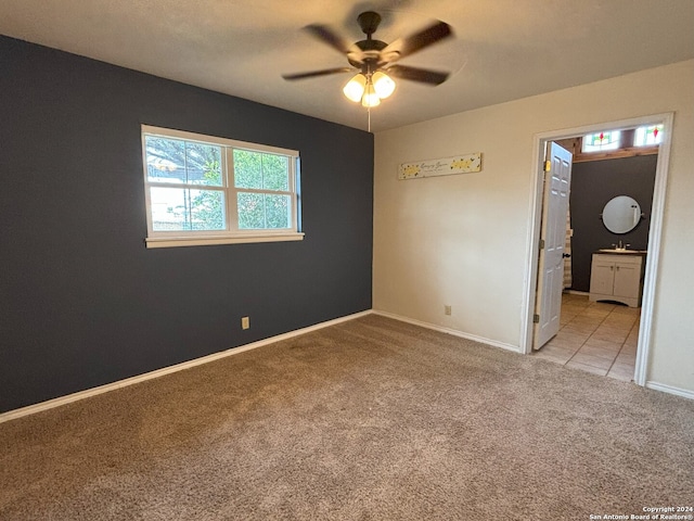 unfurnished room with carpet floors, baseboards, and a ceiling fan