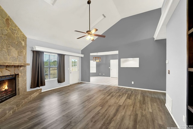 unfurnished living room featuring ceiling fan, high vaulted ceiling, wood-type flooring, and a stone fireplace