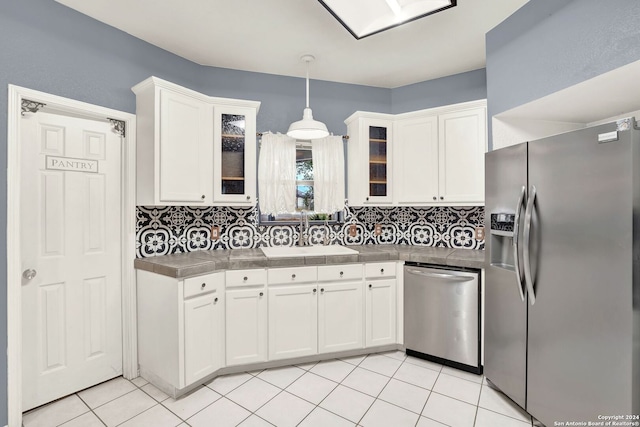 kitchen with appliances with stainless steel finishes, sink, decorative backsplash, and white cabinets