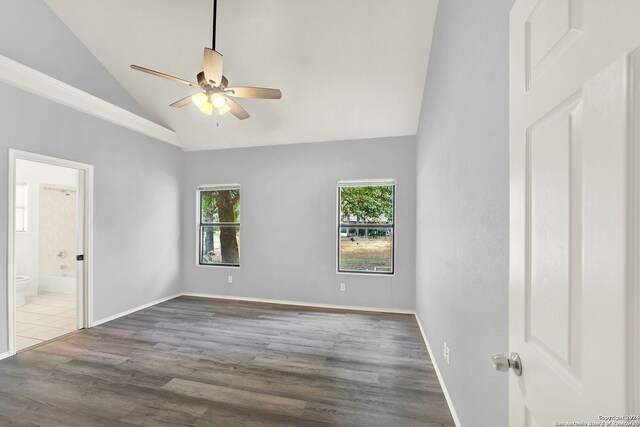 spare room featuring ceiling fan, dark wood-type flooring, and vaulted ceiling