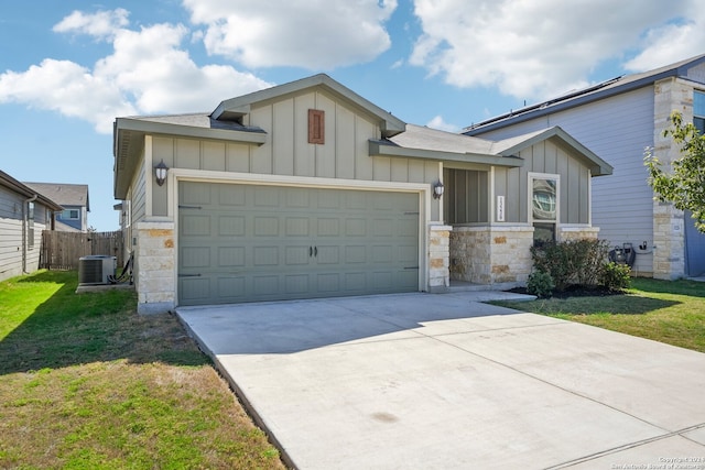 ranch-style home featuring a garage, a front lawn, and central AC unit