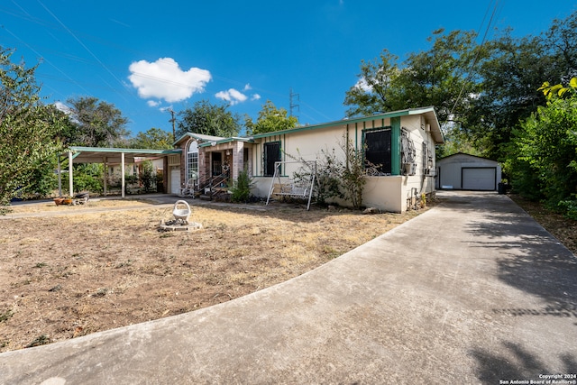 view of front of home with a garage, an outbuilding, and a carport