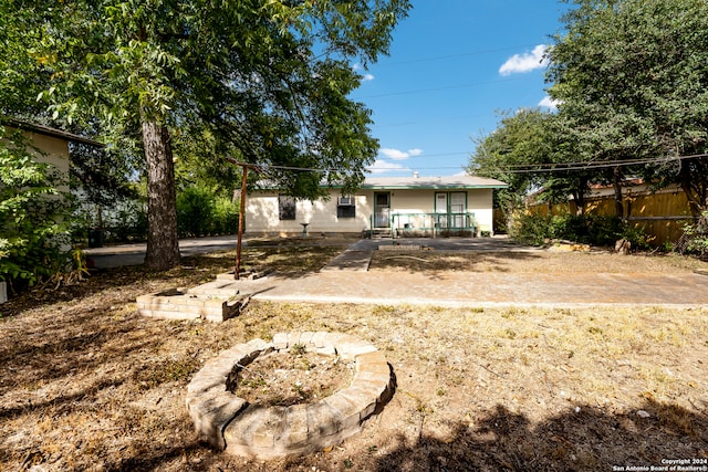 rear view of house featuring a patio area and an outdoor fire pit