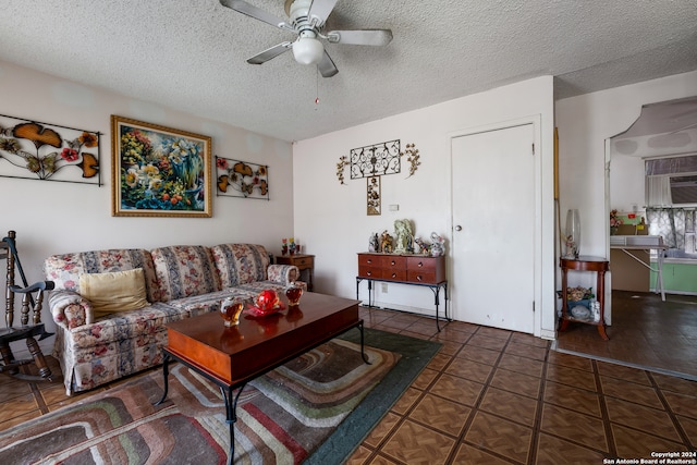 living room with dark tile patterned flooring, a textured ceiling, and ceiling fan