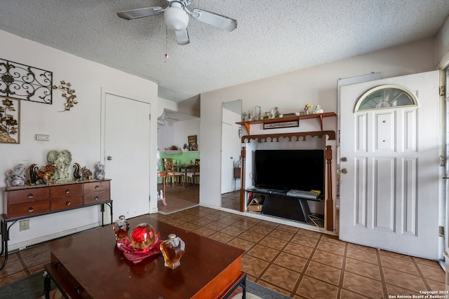 tiled living room with a textured ceiling and ceiling fan