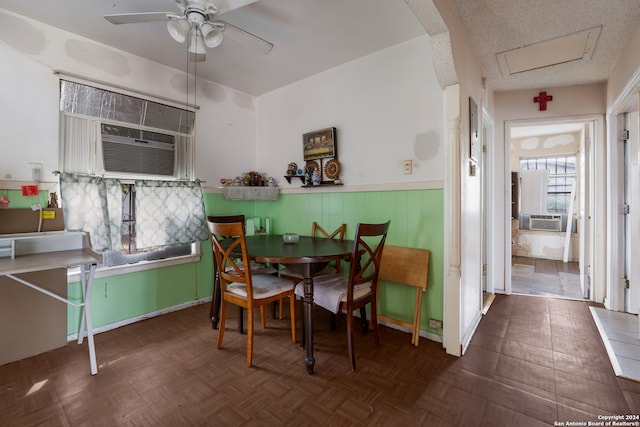 dining area with cooling unit, dark parquet floors, a textured ceiling, and ceiling fan