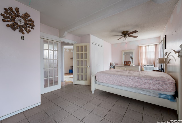 tiled bedroom with a closet, a textured ceiling, and ceiling fan