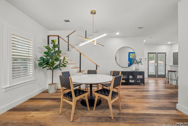 dining space with hardwood / wood-style floors and french doors