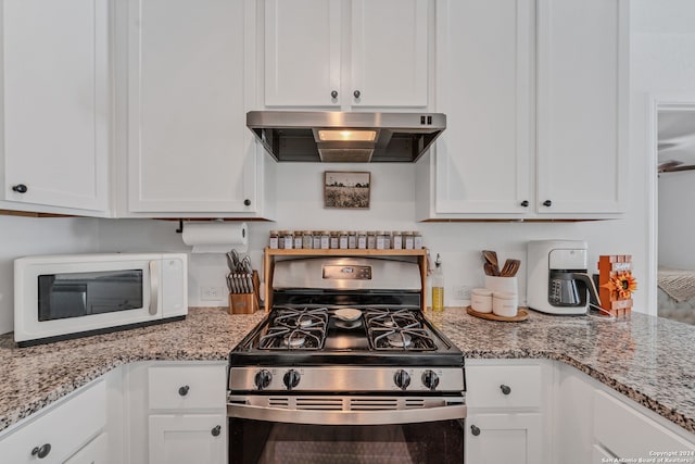 kitchen featuring ventilation hood, white cabinets, light stone counters, and stainless steel gas stove