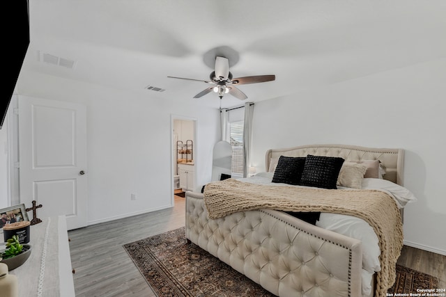 bedroom with ensuite bathroom, hardwood / wood-style flooring, and ceiling fan