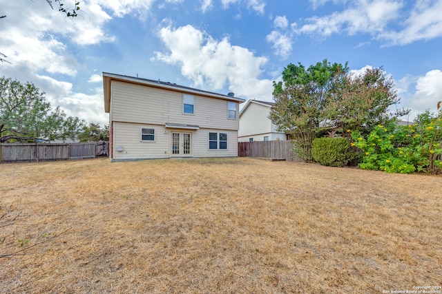 rear view of house featuring french doors and a yard