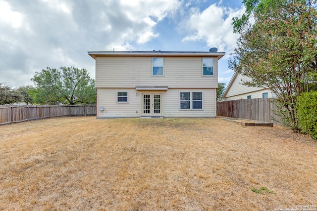 rear view of house featuring french doors and a yard