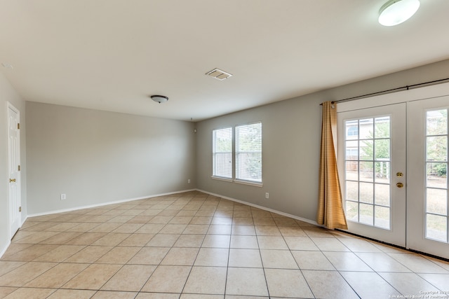 unfurnished room with french doors, plenty of natural light, and light tile patterned floors