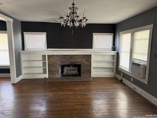 140 Jeffrey, San Antonio, TX 78201 - unfurnished living room featuring a brick fireplace, baseboards, wood-type flooring, cooling unit, and a chandelier
