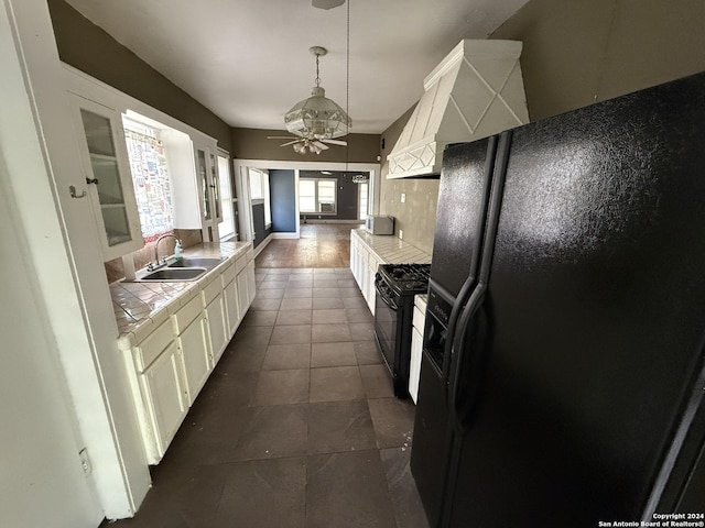 140 Jeffrey, San Antonio, TX 78201 - kitchen with ceiling fan, tile counters, white cabinets, a sink, and black appliances