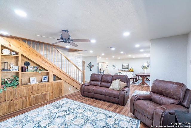 living room with a textured ceiling, hardwood / wood-style flooring, and ceiling fan