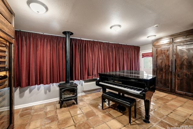 misc room with a wood stove and a textured ceiling