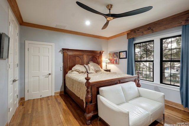 bedroom featuring crown molding, light wood-type flooring, and ceiling fan