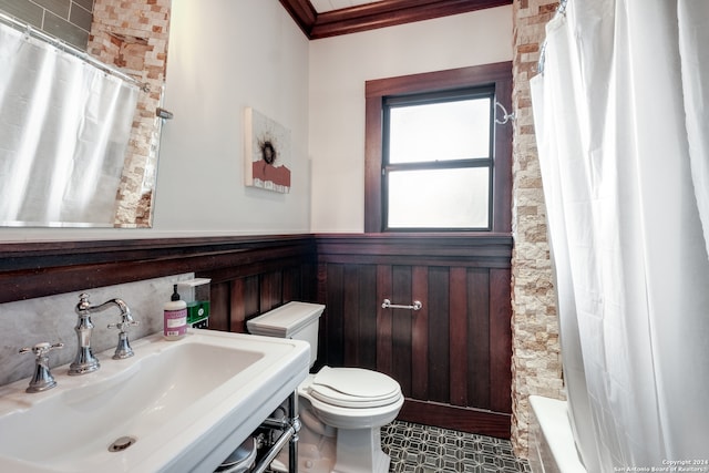 full bathroom with shower / bath combo, toilet, sink, crown molding, and wood walls