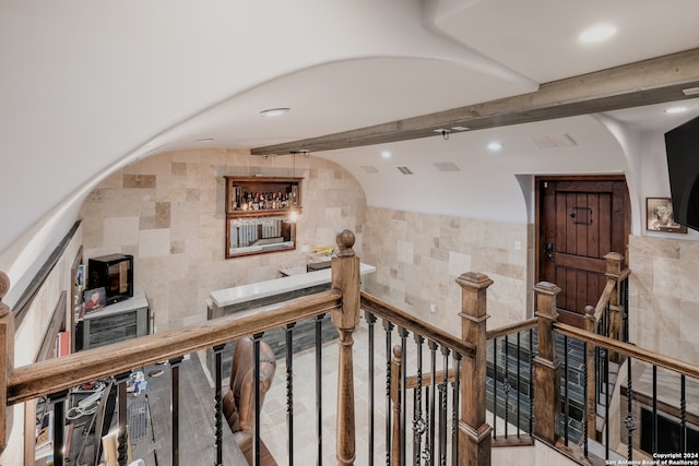 corridor with beamed ceiling and tile walls