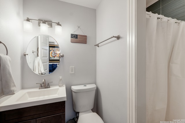 bathroom featuring vanity, curtained shower, and toilet