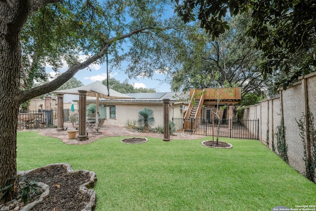 rear view of property featuring an outdoor fire pit, a patio area, and a lawn