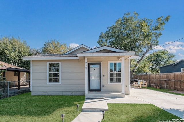 bungalow-style house featuring a front lawn and a patio area