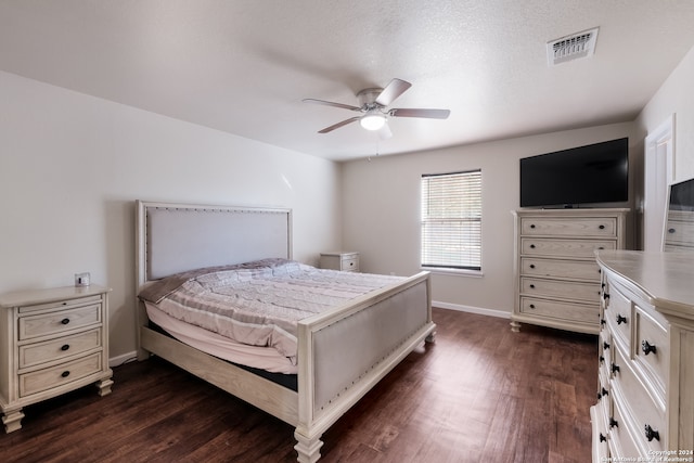 bedroom featuring ceiling fan, a textured ceiling, and dark hardwood / wood-style floors