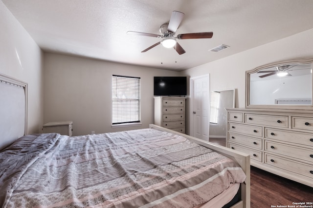 bedroom with dark wood-type flooring, ceiling fan, and a textured ceiling