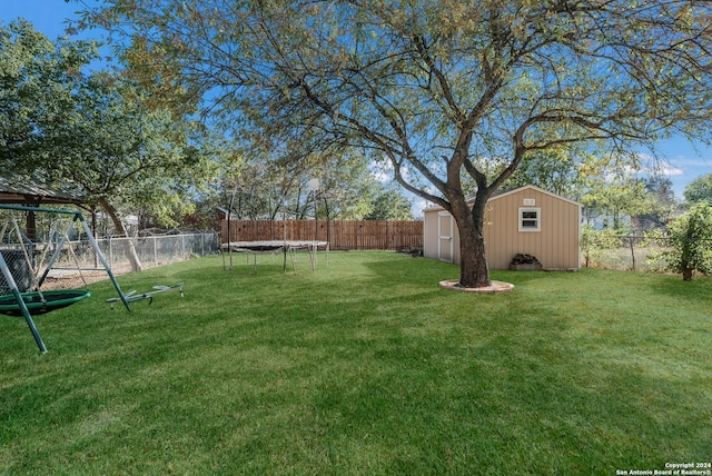 view of yard featuring a shed, a playground, and a trampoline