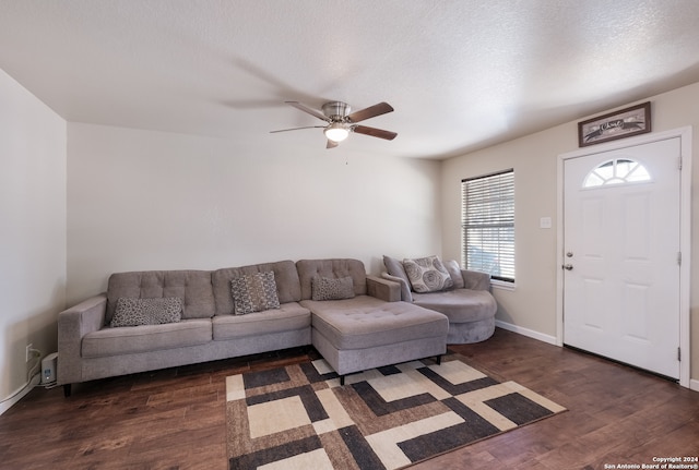 living room with a textured ceiling, dark hardwood / wood-style floors, and ceiling fan